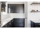 Modern kitchen with dark cabinetry, white backsplash and quartz countertops at 6202 N Galena St, Denver, CO 80238