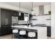 Modern kitchen with dark cabinetry, quartz countertops, and stainless steel appliances at 6202 N Galena St, Denver, CO 80238