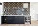 Modern wet bar with geometric wallpaper, dark cabinetry, and wine storage at 6202 N Galena St, Denver, CO 80238