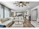 Open-concept living room with a large sectional sofa, modern decor, and view into the kitchen at 14441 Shasta Daisy Ln, Parker, CO 80134