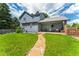A charming two-story home with a walkway, well-maintained lawn, lush landscaping, and a covered patio at 4390 S Sheridan Blvd, Littleton, CO 80123