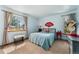 A cozy bedroom with blue walls, two windows with curtains, and a bed with red decor accenting the room at 4390 S Sheridan Blvd, Littleton, CO 80123