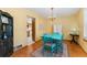 Charming dining room featuring hardwood floors, chandelier, a rustic cabinet, and kitchen access at 4390 S Sheridan Blvd, Littleton, CO 80123