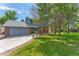 Charming two-story home with brick and siding, a well-manicured lawn, mature trees, and an attached two-car garage at 4390 S Sheridan Blvd, Littleton, CO 80123