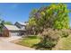 View of a two-story house with brick and blue siding, mature trees, green grass, and a 4390 mailbox at 4390 S Sheridan Blvd, Littleton, CO 80123