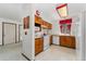 Functional kitchen with wooden cabinets, white appliances, white countertops, and easy access to other rooms at 4390 S Sheridan Blvd, Littleton, CO 80123