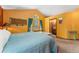 A main bedroom featuring bright yellow walls, a window with blue curtains, and entry to an en-suite bathroom at 4390 S Sheridan Blvd, Littleton, CO 80123