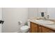 Half-bathroom features a vanity sink, mirror, and toilet in a neutral-colored setting at 9864 S Garland Ct, Littleton, CO 80127