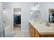 Bright bathroom featuring double vanity, soaking tub, shower, and a large walk-in closet at 9864 S Garland Ct, Littleton, CO 80127