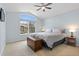 Primary bedroom featuring a queen-sized bed, an arched window, and neutral-colored walls at 9864 S Garland Ct, Littleton, CO 80127