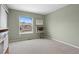 Bedroom features neutral walls, carpet, and a window with neighborhood views at 9864 S Garland Ct, Littleton, CO 80127