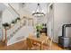 Inviting dining area with a wood burning stove, staircase, and chandelier lighting with hardwood flooring at 9864 S Garland Ct, Littleton, CO 80127