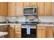 Close-up shot of the range in the kitchen featuring stainless steel appliances and sleek tile backsplash at 9864 S Garland Ct, Littleton, CO 80127