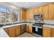 Well-lit kitchen features stainless steel appliances, a large window, and tile backsplash at 9864 S Garland Ct, Littleton, CO 80127