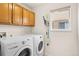 Laundry room featuring a washer, dryer, and overhead storage cabinets at 9864 S Garland Ct, Littleton, CO 80127