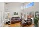 Inviting living room with soaring ceilings, lots of natural light, and comfortable leather furniture at 9864 S Garland Ct, Littleton, CO 80127