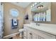 Bright bathroom with decorative window, stylish vanity and shower with blue and white curtains at 114 Walnut Dr, Frederick, CO 80530