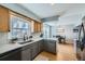 Updated kitchen features a stainless steel sink, quartz counters and views to dining area at 114 Walnut Dr, Frederick, CO 80530