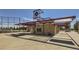 Exterior view of a building with a concrete patio, picnic tables, and a shaded seating area at 1954 S Haleyville Way, Aurora, CO 80018