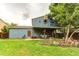 Back exterior view featuring covered patio, landscaping, and blue siding at 3916 S Telluride Ct, Aurora, CO 80013