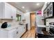 Updated kitchen featuring white cabinets, stainless appliances, and tile backsplash at 3916 S Telluride Ct, Aurora, CO 80013