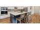 Kitchen island with seating, white countertop, and stainless steel appliances at 17214 W 94Th Ave, Arvada, CO 80007