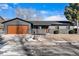 Ranch home with modern gray exterior, wood garage door and landscaping at 9163 W 75Th Cir, Arvada, CO 80005