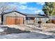 Ranch home with modern gray exterior, wood garage door and landscaping at 9163 W 75Th Cir, Arvada, CO 80005