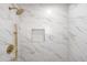 Walk-in shower with marble tile and gold fixtures at 9163 W 75Th Cir, Arvada, CO 80005