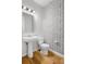 Stylish half bathroom featuring unique patterned wallpaper and sleek fixtures at 8028 Williams Fork Ave, Littleton, CO 80125