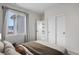 Bedroom featuring a large window, three door closet, and white walls for a spacious feel at 8028 Williams Fork Ave, Littleton, CO 80125