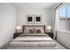 This cozy bedroom features neutral tones, two side tables with lamps, and natural light from the window at 8028 Williams Fork Ave, Littleton, CO 80125