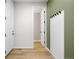 Inviting hallway featuring light wood floors and modern wainscoting detail at 8028 Williams Fork Ave, Littleton, CO 80125