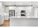 Spacious kitchen featuring a large island with white countertops and shaker style cabinets with stainless steel appliances at 8028 Williams Fork Ave, Littleton, CO 80125