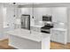Bright kitchen with stainless steel appliances, an island with white countertops, and modern lighting at 8028 Williams Fork Ave, Littleton, CO 80125