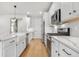 Well-lit kitchen featuring a farmhouse sink, stainless steel appliances, and tile backsplash at 8028 Williams Fork Ave, Littleton, CO 80125