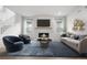 Bright living room featuring a cozy fireplace, stylish seating, a large area rug and hardwood flooring at 8028 Williams Fork Ave, Littleton, CO 80125