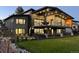 Modern home with a backyard featuring a manicured lawn, lush landscaping, and a spacious covered deck at 10106 W 69Th Pl, Arvada, CO 80004