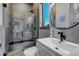 Modern bathroom with sleek vanity, toilet, and glass-enclosed shower featuring gray tiles and a convenient built-in bench at 10106 W 69Th Pl, Arvada, CO 80004