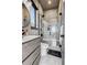 Well-lit bathroom with a modern vanity, toilet, and glass-enclosed shower, complemented by marble flooring and neutral tones at 10106 W 69Th Pl, Arvada, CO 80004