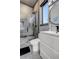 Contemporary bathroom with a round mirror, toilet, and frameless glass shower accented by gray tiling and dark fixtures at 10106 W 69Th Pl, Arvada, CO 80004