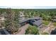 Aerial view of a modern home with a manicured yard and mature trees in a suburban neighborhood at 10106 W 69Th Pl, Arvada, CO 80004