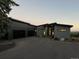 Modern home with a large driveway and minimalist landscaping at dusk at 10106 W 69Th Pl, Arvada, CO 80004