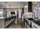 Modern kitchen with a large island, stainless steel sink, and eye-catching multi-colored brick backsplash at 10106 W 69Th Pl, Arvada, CO 80004