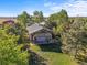 Aerial view of a charming barn nestled amongst mature trees and lush greenery at 11510 Lewistown St, Commerce City, CO 80022