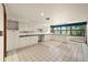 Bright kitchen with tile floors, white cabinets and granite countertops, and window with a view at 11510 Lewistown St, Commerce City, CO 80022
