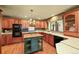 Charming kitchen with wooden cabinets, a center island and black appliances at 11510 Lewistown St, Commerce City, CO 80022
