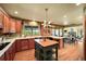 Spacious kitchen with wood cabinets, an island, hardwood floors, and an eat-in area with a fireplace at 11510 Lewistown St, Commerce City, CO 80022