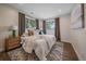 Cozy bedroom showcasing a plush bed, stylish rug, and abundant natural light from two windows at 805 Elm St, Denver, CO 80220