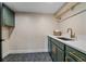 Bright laundry room featuring hexagon tile floor, and green cabinets with gold hardware at 805 Elm St, Denver, CO 80220